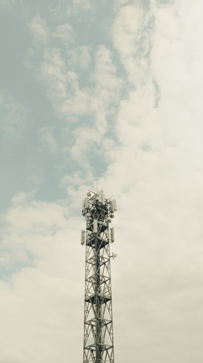 A tall radio tower stands against a cloudy sky showcasing telecommunication technology.