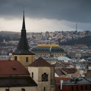 Discover a moody cityscape of Prague with stunning dark clouds and historic architecture.