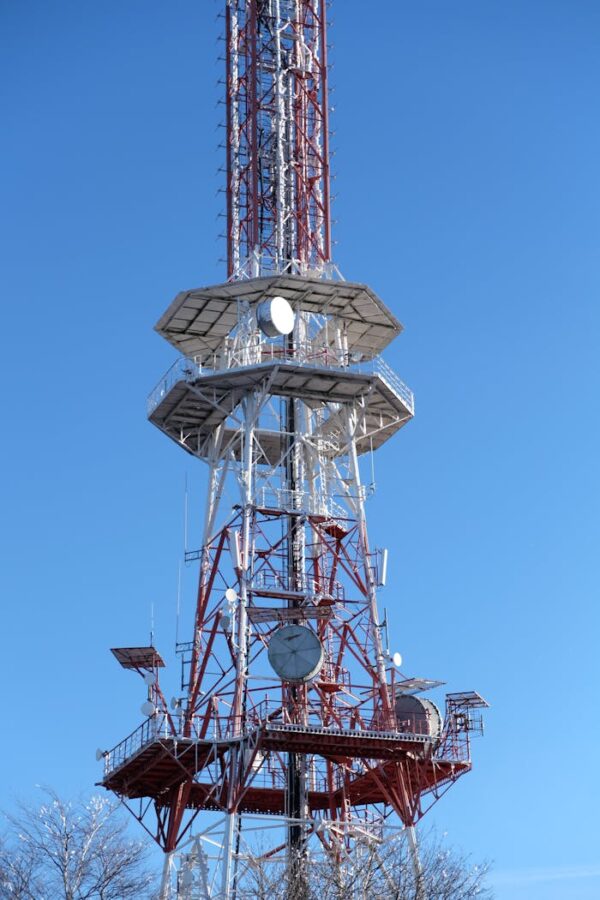 A tall communication tower set against a clear blue sky, showcasing modern infrastructure.